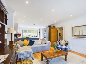 Uma sala de estar com sofá, mesa de centro e um quadro na parede.