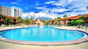 Una piscina rodeada de palmeras y edificios.