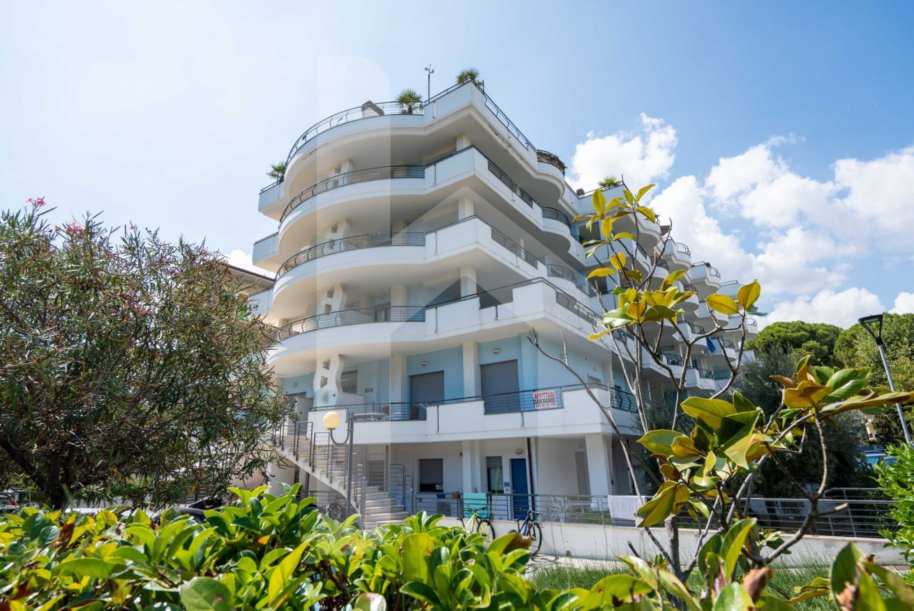 Un edificio de varios pisos con balcones, una escalera y un letrero que indica que es un hotel.