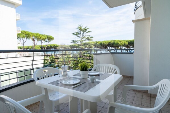 A balcony with a table set for two, white plastic chairs, and a potted plant. - Holiday Rendez Vous 46- Third floor apartment with sea view (Pineto)