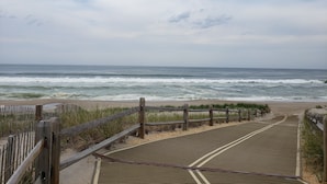 A wooden boardwalk leading to a beach with waves crashing onto the shore. - 5BR/3BTH waterfront family beach house with hot tub, kayaks, bikes and game room (Mantoloking)
