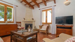 Una sala de estar acogedora con chimenea, televisor y asientos cómodos.