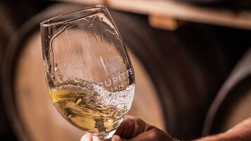A hand holding a wine glass with a label that reads "CUPITS ESTATE 1744".