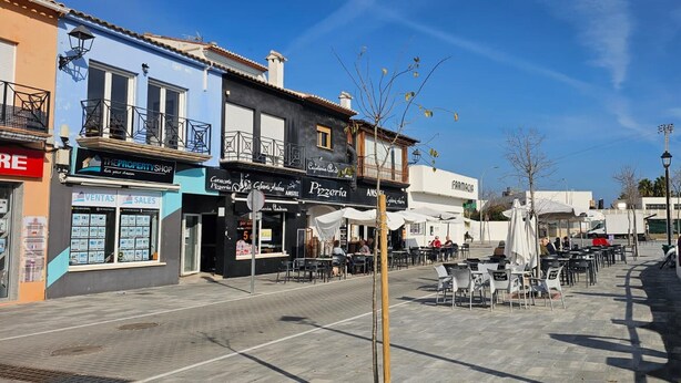 A street with outdoor seating, a property shop, and a pizza place. - Apartment ANDRES in the center of Els Poblets (Poblets (els))