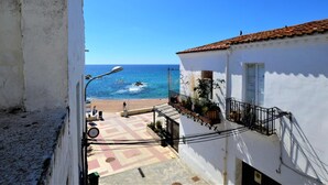 Blick vom Balkon auf einen Strand bei blauem Himmel.