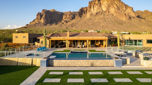 A modern house with a pool, outdoor seating, and a view of a mountain. - Beautiful oasis with 40' negative edge pool, swim up bar, hiking in Super. Mtns. (Apache Junction)