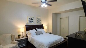 A bedroom with a bed, bedside tables, a chair, a desk, and a ceiling fan. - Beautiful 3BR&2BA House located in the Historic part of Brownville-SPI-SpaceX-MX (Brownsville)