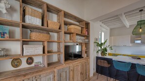 Une cuisine rustique avec des étagères en bois, un téléviseur et un coin bar équipé de chaises.