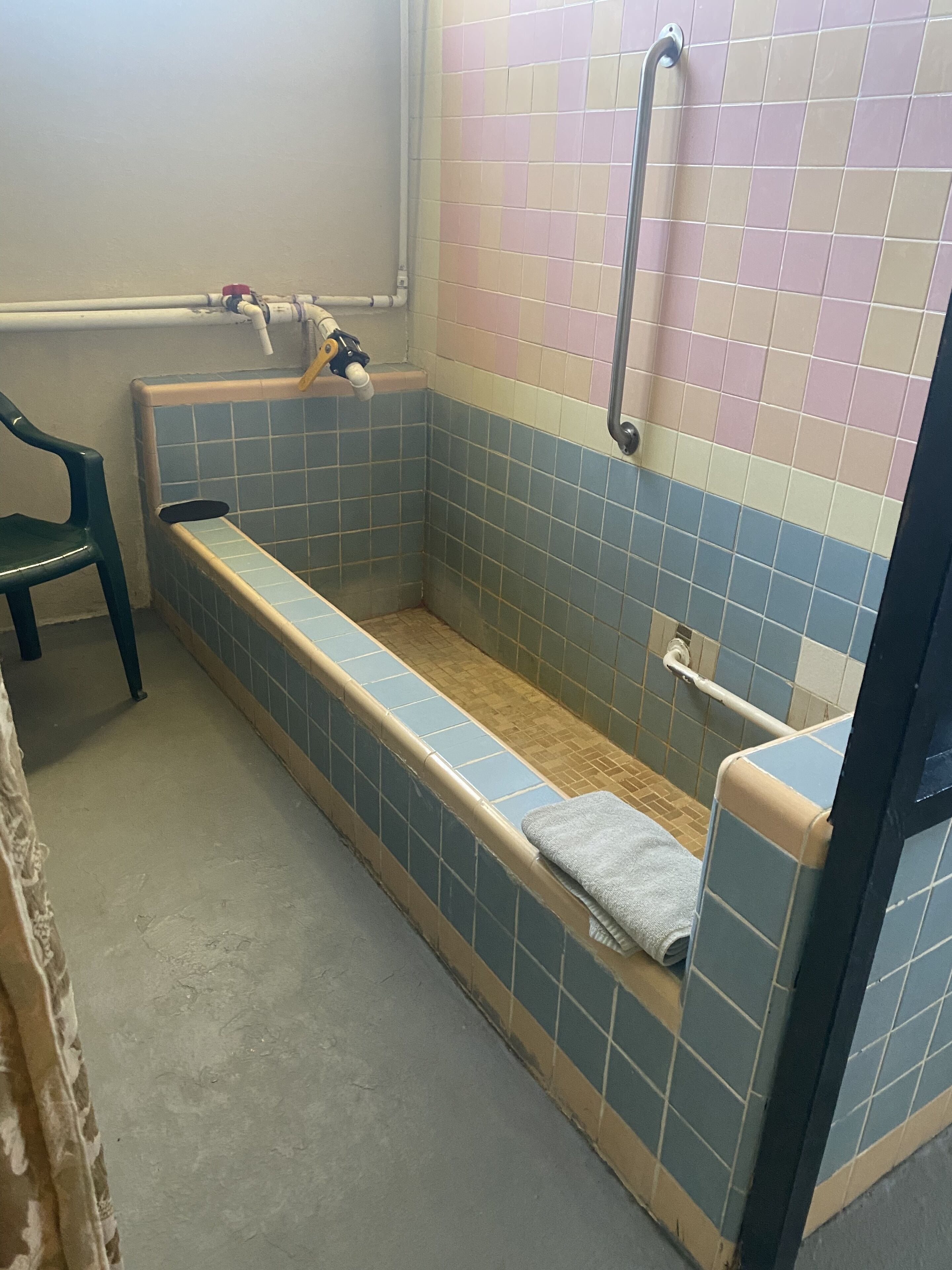Et badeværelse med badekar, bruser og toilet.