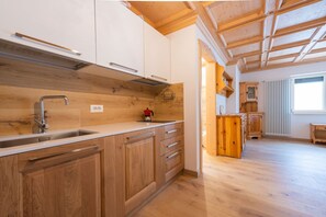 Une cuisine avec des meubles de rangement en bois, un évier et une fenêtre.