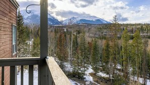 A wooden cabin with a balcony overlooking a snowy mountain landscape and a forest. - New Lamartine Condos Building 2 Unit #2533 by Summit County Mountain Retreats (Silverthorne)