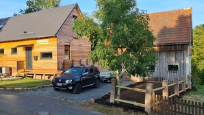 A wooden building with a sloped roof, a car parked in front, and a wooden fence. - Fantastic chalet with outdoor WHIRLPOOL. NEW since 2024: outdoor SAUNA!!! (Gersfeld (Rhön))