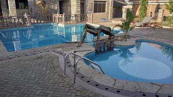 Piscina externa, guarda-sóis, salva-vidas no local
