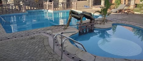 Een buitenzwembad, parasols voor strand/zwembad, badmeesters op locatie