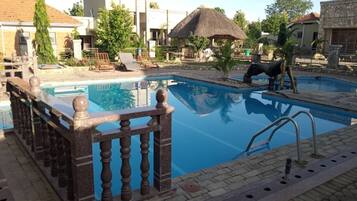 Outdoor pool, pool umbrellas, lifeguards on site