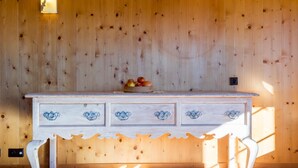 A wooden wall with a white cabinet featuring blue floral handles.