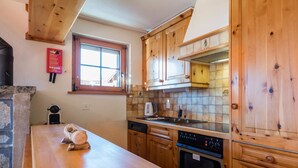 A kitchen with wooden cabinets, a stove, and a window.