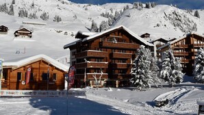 A snow-covered mountain resort with wooden buildings and ski slopes.