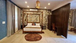 A bedroom with a four-poster bed, stone wall, and a large window with curtains. - 1B-Wild Heritage-101 N By bnbmehomes (Salt)
