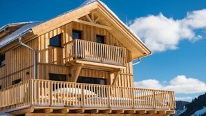 A wooden chalet with a balcony and a ski lift chair. - Superior #43 mit Sprudelwanne by Interhome (Hohentauern)