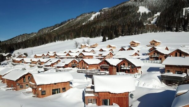 A snow-covered village with wooden cabins, a mountain backdrop, and a clear sky. - Superior #43 mit Sprudelwanne by Interhome (Hohentauern)