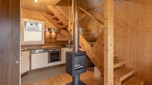 A wooden interior with a kitchen, stove, and staircase. - Superior #43 mit Sprudelwanne by Interhome (Hohentauern)