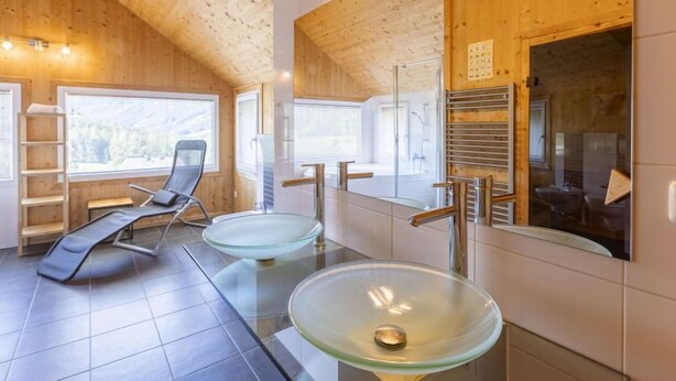 A modern bathroom with wooden walls, two glass sinks, a shower, and a chair. - Premium #18 mit Sauna&Sprudelbad by Interhome (Hohentauern)
