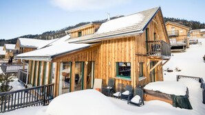 A wooden chalet with a balcony, surrounded by snow-covered hills. - Premium #14 mit IR-Sauna by Interhome (Hohentauern)