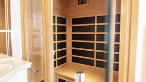 A sauna with wooden walls and shelves, a bench, and a control panel. - Premium #14 mit IR-Sauna by Interhome (Hohentauern)