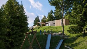 A playground with swings and slides, surrounded by trees and a building in the background. - mit 2 Schlafzimmern by Interhome (Kötschach-Mauthen)