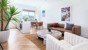 Un soggiorno moderno con un divano, un tavolino, un'area pranzo e una cucina.