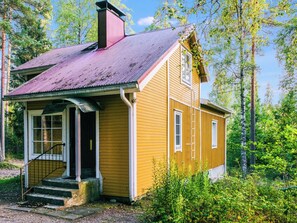 A small, single-story wooden house with a porch, a chimney, and a window. - Hiljanrinne by Interhome (Hausjärvi)
