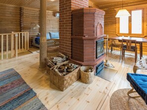 Un intérieur de chalet chaleureux avec une cheminée, des meubles en bois et un coin repas.