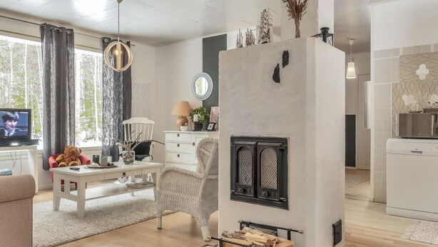 A modern living room with a fireplace, a television, and a cozy seating area.