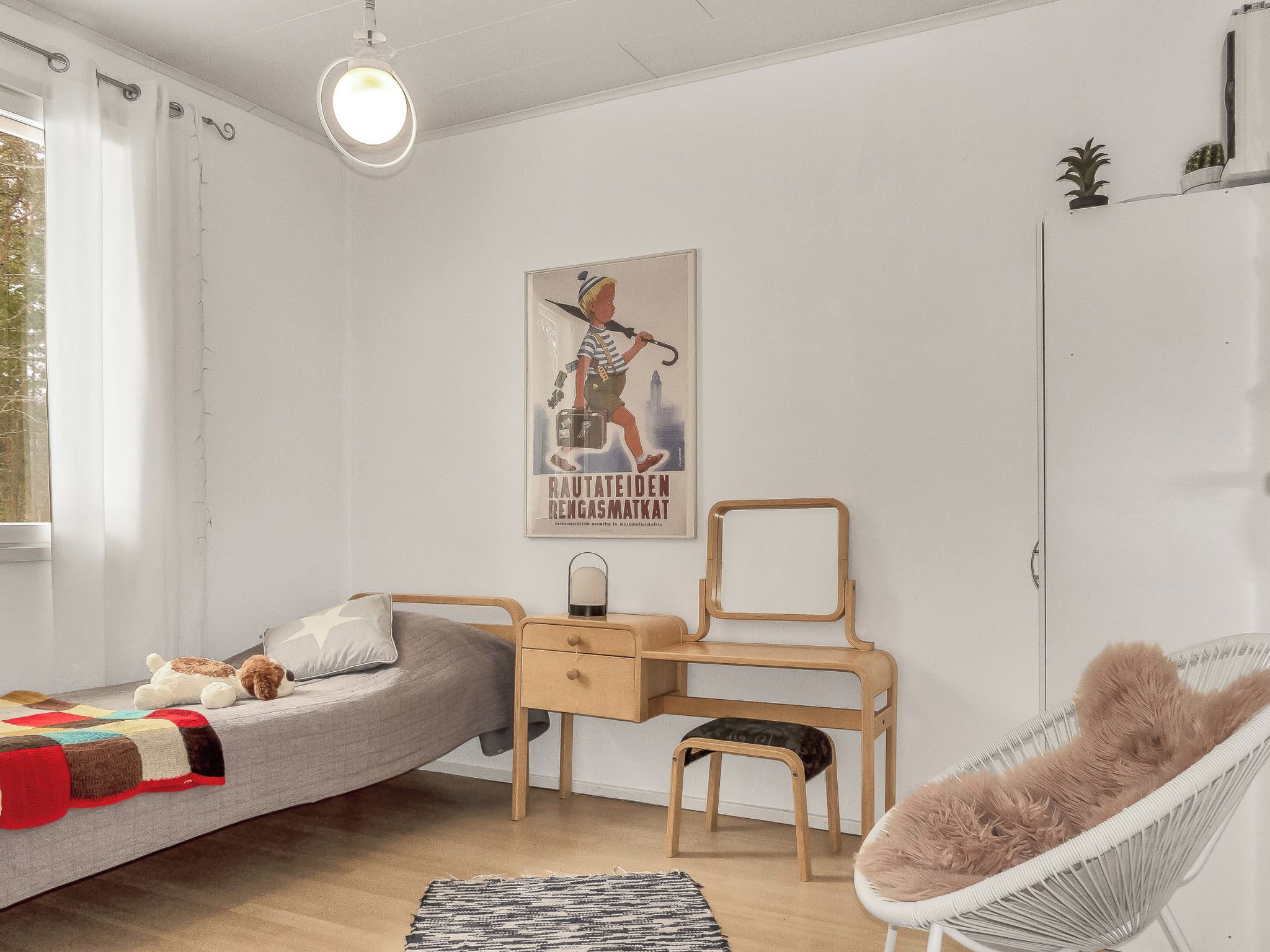 Un dormitorio con cama, escritorio, silla y un cartel en la pared.