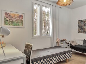 A minimalist bedroom with a bed, a desk, a chair, a window, and a wall-mounted shelf. - Huvikumpu by Interhome (Hailuoto)