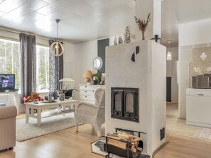 A modern living room with a fireplace, a television, and a dining area.