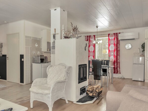 A living room with a fireplace, dining area, and kitchen.