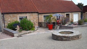 A stone building with a red-tiled roof, a stone staircase, and a gravel driveway. - The deer house (Plouigneau)