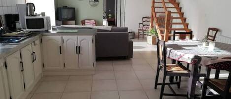 A kitchen with a dining area, a staircase, and a living room.