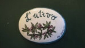 A white stone with the inscription "L'ulivo" and a floral design. - Carla's House-Apartment The Olive Tree (Ravello)