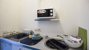 A kitchen with a microwave, sink, and various utensils. - Carla's House-Apartment The Olive Tree (Ravello)
