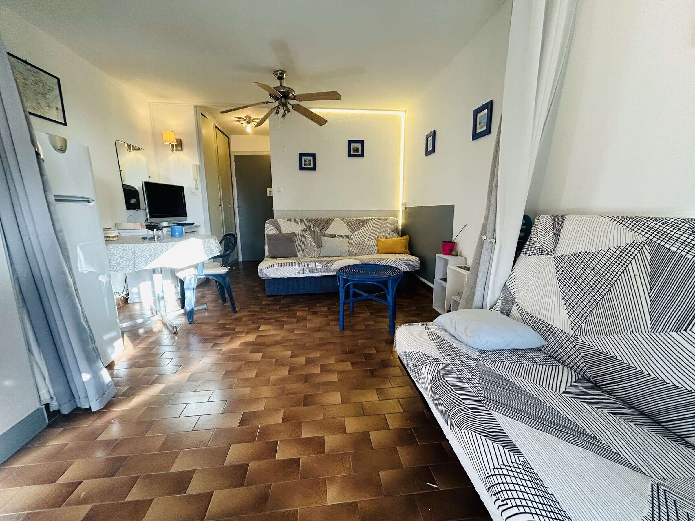 A compact living space with a sofa, a dining table, and a TV.