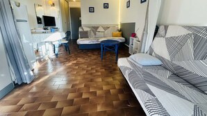 Un espacio habitable compacto con sofá, mesa de comedor y televisor.