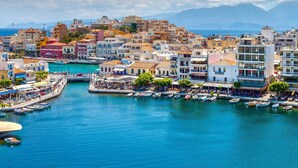 Une ville côtière dotée d’un port de plaisance rempli de bateaux, de bâtiments avec des balcons et offrant une vue dégagée sur la mer.