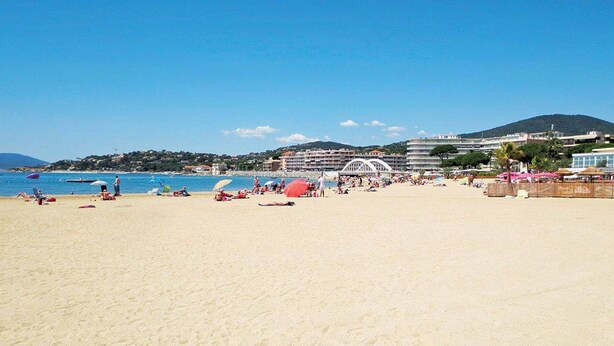 A beach with a clear sky, a bridge, and buildings in the background. - Cozy 2-Room Apartment with Pool, Parking, and Near the Beach (Sainte-Maxime)
