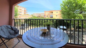 A balcony with a round table, a chair, and a potted plant. - Cozy 2-Room Apartment with Pool, Parking, and Near the Beach (Sainte-Maxime)