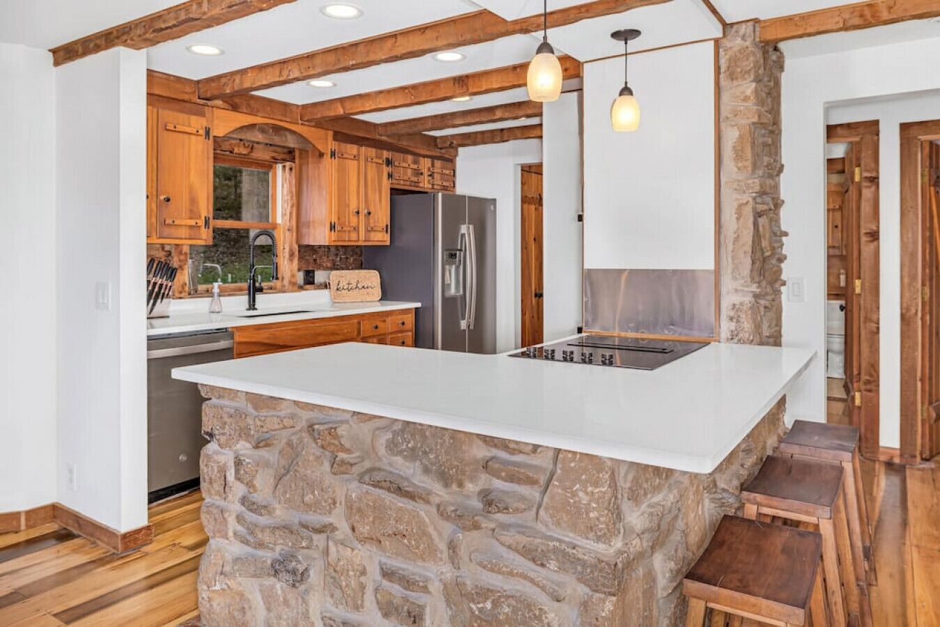 A kitchen with a stone island, wooden cabinets, and a built-in refrigerator.