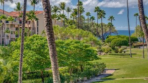 Un resort con palmeras, un césped bien cuidado y un edificio de techo rojo.