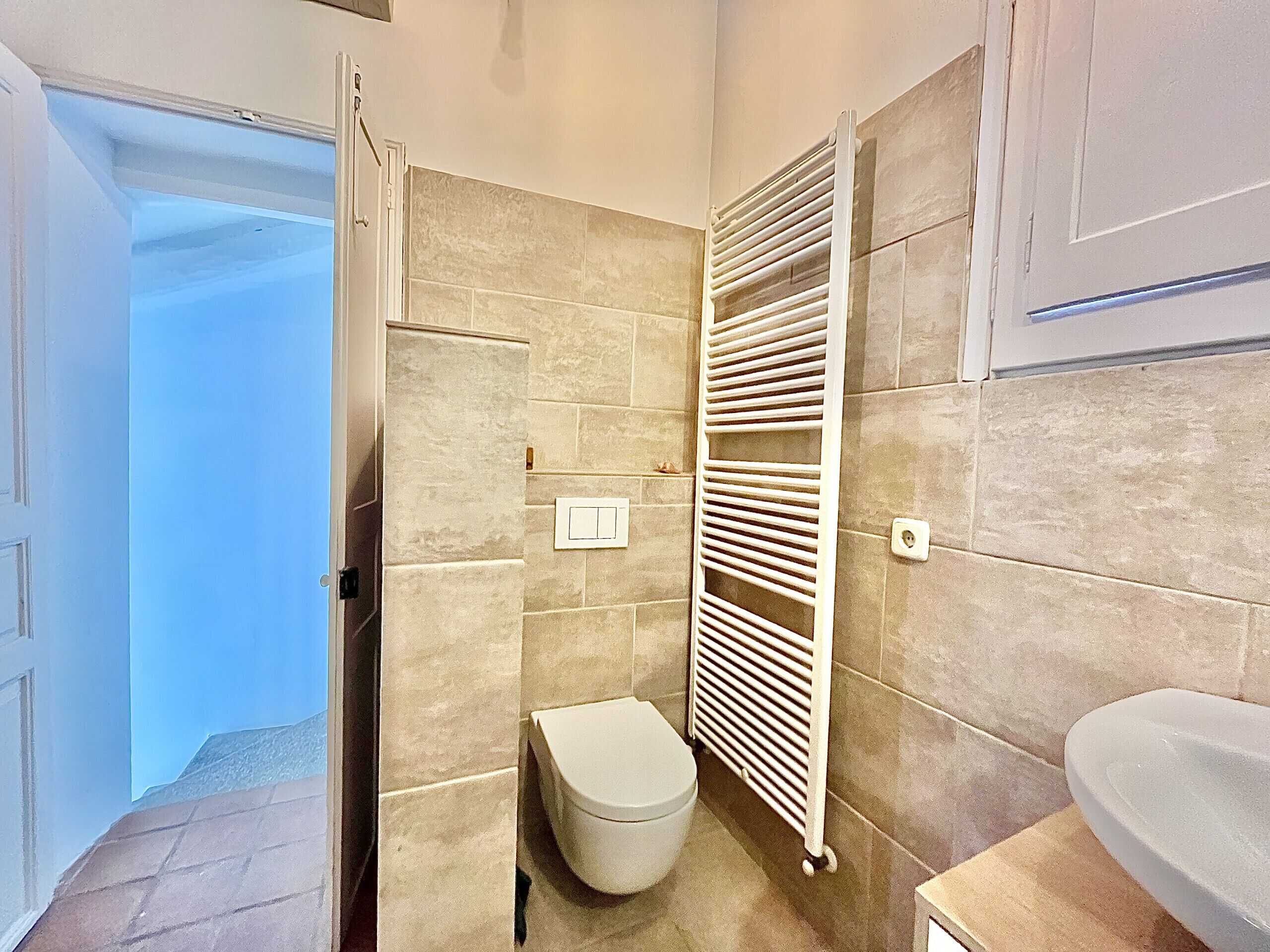 A bathroom with a toilet, a radiator, and a sink.